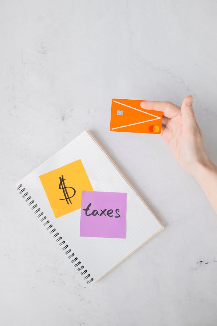 Overhead view of tax planning setup with credit card and notes on white surface.